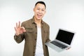 Smiling happy asian man holding a laptop in his hands on a white studio background Royalty Free Stock Photo