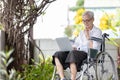 Smiling happy asian senior woman sitting in wheelchair,enjoying her retirement income,old elderly with laptop computer alone at