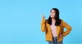 Smiling happy asian woman with her finger pointing  on light blue banner background with copy space Royalty Free Stock Photo