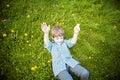 Smiling happy boy laying in grass outside picking flowers Royalty Free Stock Photo