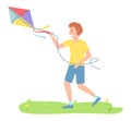 Smiling happy boy in the park playing with a kite flying in the wind. Child running holding thread Royalty Free Stock Photo