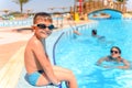 Smiling happy boy sitting at the edge of a pool Royalty Free Stock Photo