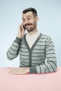 Smiling happy business man talking on phone sitting at the table Royalty Free Stock Photo