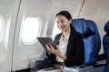 Smiling happy business woman asian flying and working in an airplane in first class, Woman sitting inside an airplane Royalty Free Stock Photo