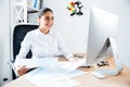 Smiling happy businesswoman holding reports and looking at computer Royalty Free Stock Photo