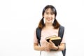 Smiling happy and casual Asian female college students holding pile of books with bag isolated over white background. Royalty Free Stock Photo