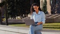 Smiling happy cheerful carefree young girl student winner successful business woman with laptop sitting in city street Royalty Free Stock Photo