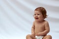 Smiling happy child . Portrait of little girl , baby in diaper joyfully sitting and laughing on white studio Royalty Free Stock Photo