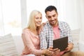 Smiling happy couple with tablet pc at home Royalty Free Stock Photo