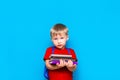 Smiling happy cute clever boy with backpack. Child with a pile of books in his hands. blue background. Ready for school. Back to Royalty Free Stock Photo