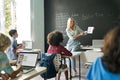 Smiling happy cute teacher having mathematics lesson class sitting on desk. Royalty Free Stock Photo