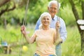 Senior couple outdoors with tree swing Royalty Free Stock Photo