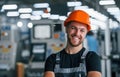 Smiling and happy employee. Portrait of industrial worker indoors in factory. Young technician with orange hard hat