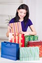 Smiling happy girl prepares bags gifts for Christmas Royalty Free Stock Photo