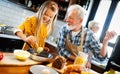 Smiling grandfather helping children to cook in the kitchen Royalty Free Stock Photo