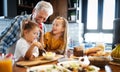 Smiling grandfather helping children to cook in the kitchen Royalty Free Stock Photo