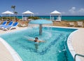 Smiling happy litle girl enjoying swimming and relaxing in water pool with natural sea water Royalty Free Stock Photo