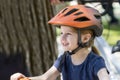 Smiling and Happy Little Girl with Helmet Stands with Her Bicycle in a Park Royalty Free Stock Photo