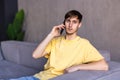 Smiling happy man using laptop and talking on phone at home, having pleasant conversation with friend or client, typing, satisfied Royalty Free Stock Photo