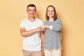 Smiling happy man and woman wearing casual clothing standing with fist bump looking at camera with cheerful expression good job Royalty Free Stock Photo