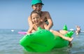 Smiling happy mother and son playing on the wave in the sea in the daytime. Happy family relaxing by the sea. Summer, spring and w Royalty Free Stock Photo