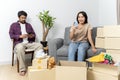 Smiling happy moving to a new house. Asian couple relaxing with smartphone at home, loving man and woman sitting on couch together Royalty Free Stock Photo