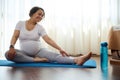 Smiling happy pregnant woman doing prenatal stretching exercises on yoga mat, stretching body for wellness in pregnancy Royalty Free Stock Photo