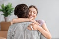 Smiling happy pretty young european wife hugs husband and shows key from new own apartment in room interior Royalty Free Stock Photo