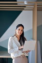 Happy professional young latin business woman holding laptop standing in office. Royalty Free Stock Photo