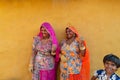 Smiling and happy Rajasthani women and children in local costume, posing in a Rajasthani village