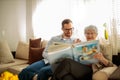 Senior woman looking at old family photos with her grandson Royalty Free Stock Photo