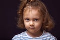 Smiling happy  small kid girl with grimacing face looking fun and decided the question on black studio background with empty copy Royalty Free Stock Photo