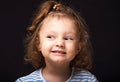 Smiling happy  small kid girl with grimacing face looking up and decided the question on black studio background. Closeup Royalty Free Stock Photo