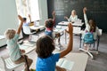 Smiling happy teacher having maths lesson with schoolkids sitting at desk. Royalty Free Stock Photo