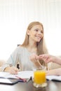 Smiling teenage girl doing homework in living room