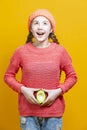 Smiling Happy Teenage Girl In Coral Knitted Clothing With Split Avocado Fruit In Front of Belly as a Demonstration of Female