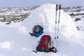 Smiling happy tourist in a snowy house igloo with a metal wine-glass of alcohol beverage Royalty Free Stock Photo