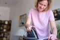 Smiling happy woman irons clothes on ironing board Royalty Free Stock Photo
