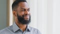 Smiling happy young African American guy, company employee holding glass getting drink of pure cold water. Healthy mixed Royalty Free Stock Photo