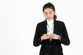 Smiling happy young Asian business woman in suit holding mobile smart phone over white isolated background Royalty Free Stock Photo