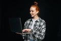 Smiling happy young business woman or student holding laptop computer and looking at display. Royalty Free Stock Photo