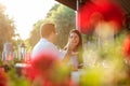 Smiling happy young couple enjoying dinner in outdoor restaurant, surrounded by green trees Royalty Free Stock Photo
