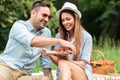 Smiling happy young couple enjoying their time in a park, having a casual romantic picnic