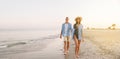 Smiling happy young couple, man and woman, wearing a blue shirt, holding hands, looking at each other, walking together Royalty Free Stock Photo