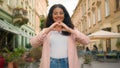 Smiling happy young teen Indian Arabian woman female lady girl making heart shape hands to camera laughing positive Royalty Free Stock Photo