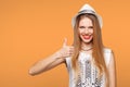 Smiling happy young woman showing thumbs up, isolated on orange background Royalty Free Stock Photo