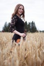 Smiling happy young woman violinist in a wheat field