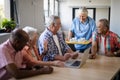 Smiling healthcare worker serving coffee to senior people Royalty Free Stock Photo