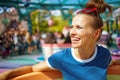 Healthy woman in blue t-shirt in theme park having ride