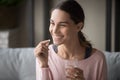 Smiling healthy woman holding pill glass of water at home